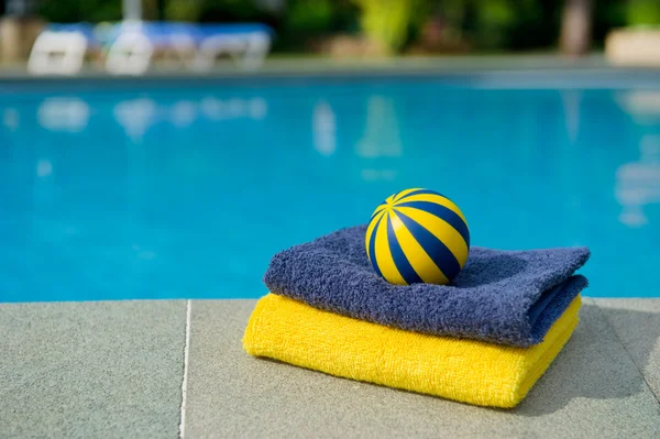 Asciugamani e giocattoli vicino alla piscina — Foto Stock