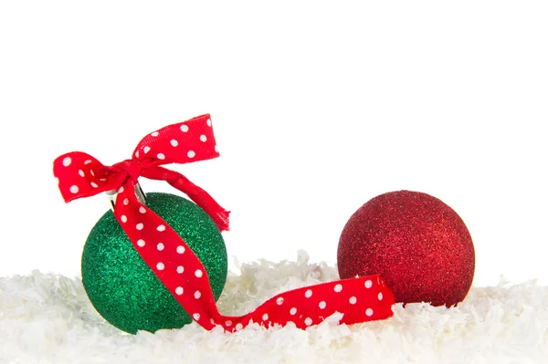 Groene en rode kerstballen in sneeuw — Stockfoto