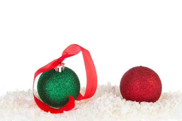 Bolas de Navidad verdes y rojas en la nieve — Foto de Stock