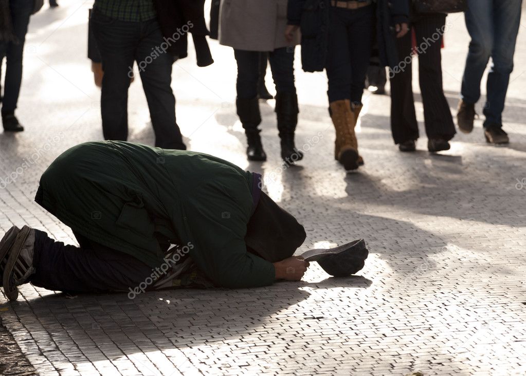 Beggar kneeling on a pavement