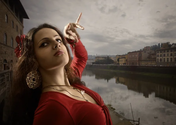 Woman in red dress dances on the bank of the Arno. — Stock Photo, Image