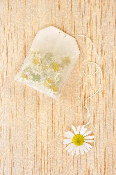 Bag of chamomile tea over wooden background - concept — Stock Photo, Image
