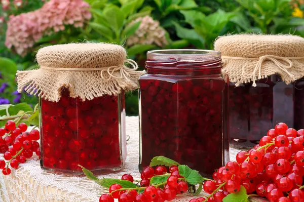 Potten van zelfgemaakte rode bessen jam met vers fruit — Stockfoto