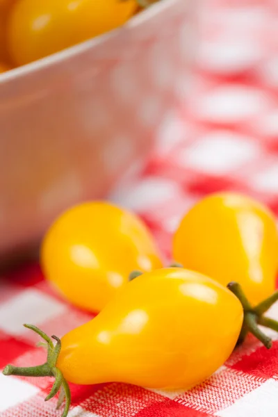 Gele tomaten op picknick tafellaken — Stockfoto