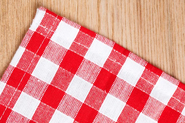 Checkered tablecloth on wooden table — Stock Photo, Image