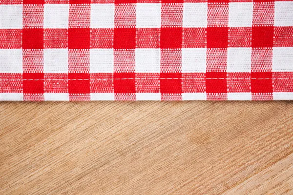 Checkered tablecloth on wooden table — Stock Photo, Image