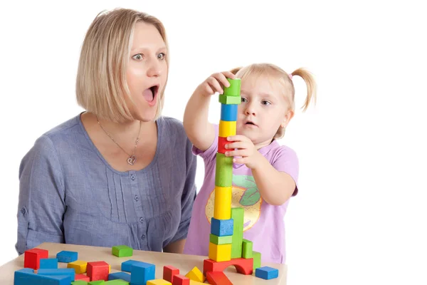Liten flicka och hennes mamma leker med leksak block — Stockfoto