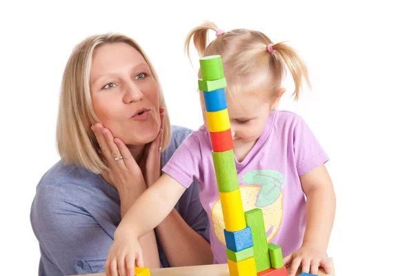 Маленька дівчинка і її мати грають з іграшковими блоками — стокове фото