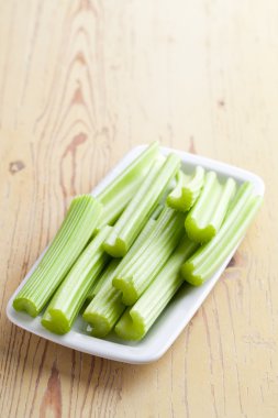 Green celery sticks on kitchen table clipart