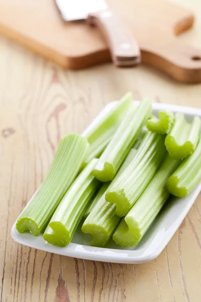 Green celery sticks on kitchen table Royalty Free Stock Images