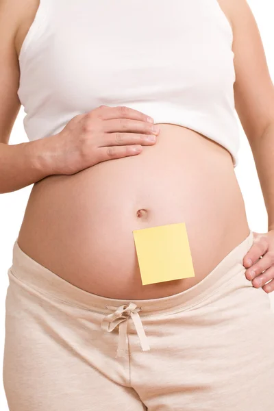 Pregnant women with notepaper on her belly — Stock Photo, Image