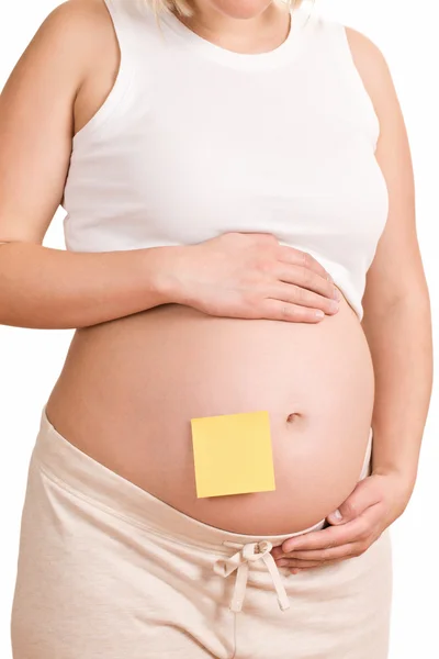 Gravida kvinnor med brevpapper på hennes mage — Stockfoto
