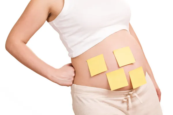 stock image Pregnant women with notepaper on her belly