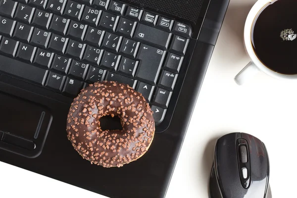 Pause im Büro. Donut auf Laptop-Tastatur — Stockfoto