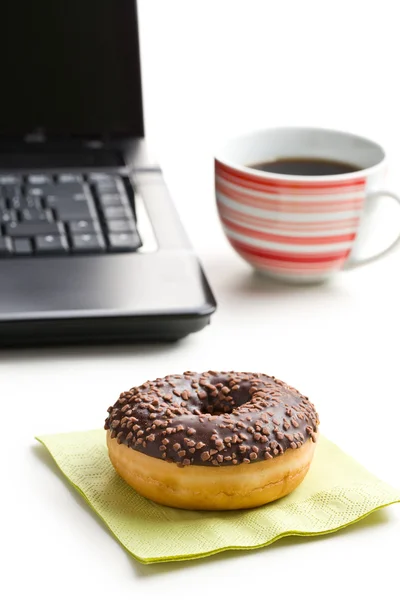 Перерыв в офисе. пончик на клавиатуре ноутбука — стоковое фото