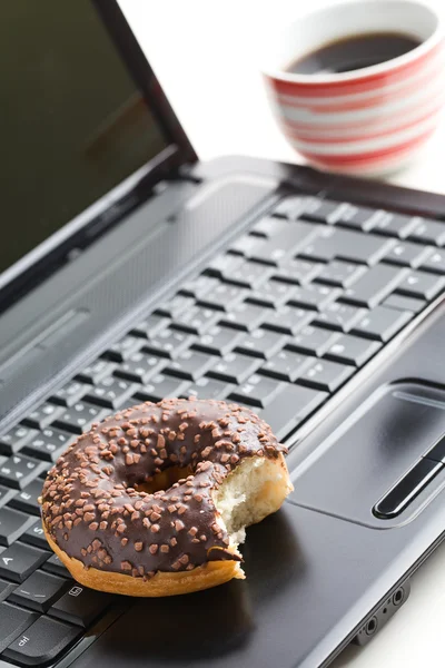 कार्यालय में तोड़ो। लैपटॉप कीबोर्ड पर डोनट — स्टॉक फ़ोटो, इमेज