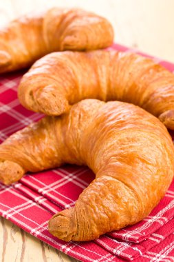 Fresh croissants on checkered napkin clipart