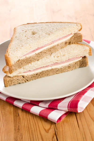 Broodje ham op geruite servet — Stockfoto