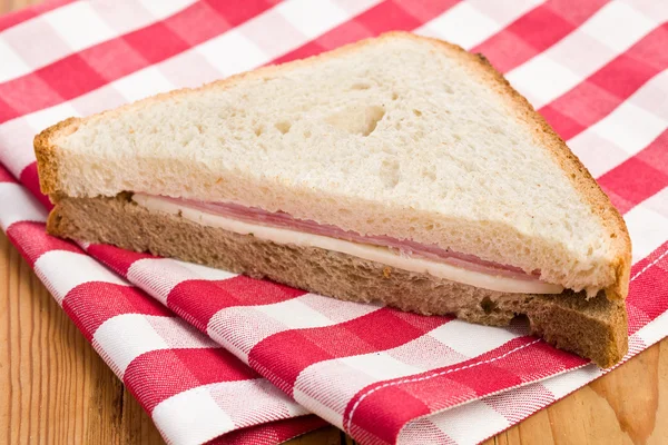 Broodje ham op geruite servet — Stockfoto