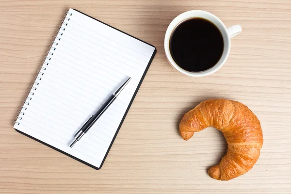 Croissant with coffee and notepad — Stock Photo, Image