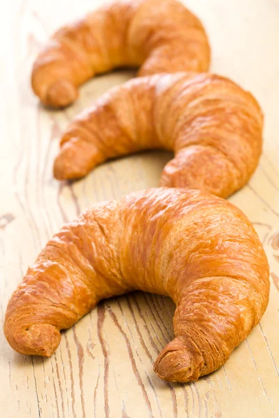 Fresh croissant on wooden table — Stock Photo, Image