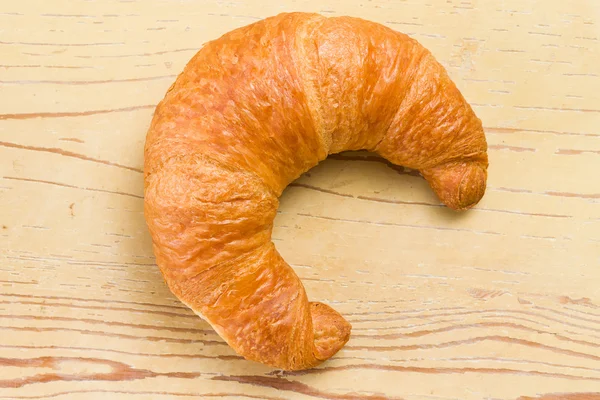 Frisches Croissant auf Holztisch — Stockfoto