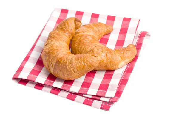 Frische Croissants auf karierter Serviette — Stockfoto