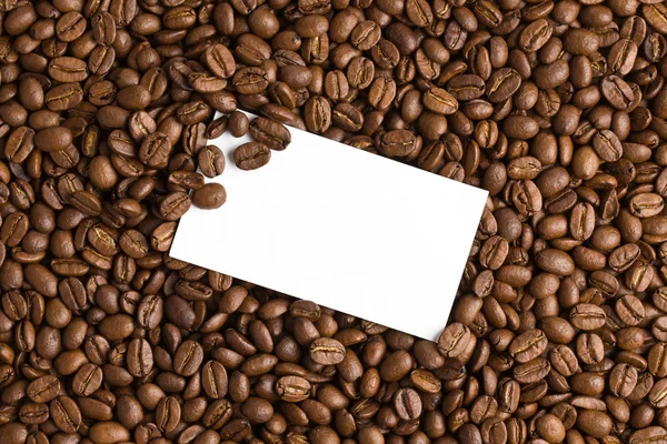 Kahve çekirdekleri zemin üzerine beyaz kart — Stok fotoğraf