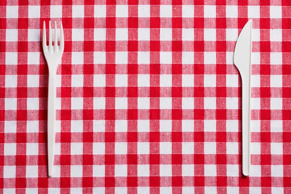 市松模様のテーブル クロスにプラスチック製のカトラリー — ストック写真