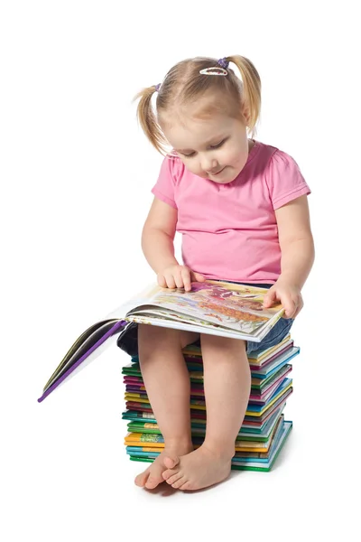 Et lite barn som leser en bok – stockfoto