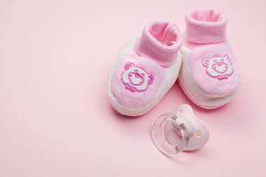 Pink baby shoes and pacifier clipart