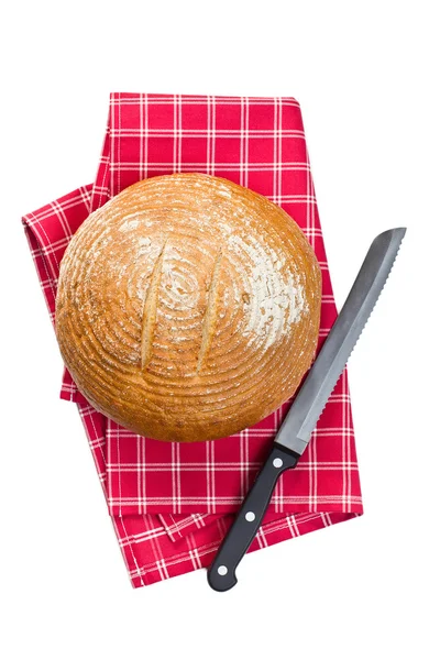 Round bread with knife on checkered napkin — Stock Photo, Image