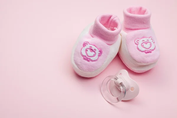 Růžové dětské boty a dudlík — Stock fotografie