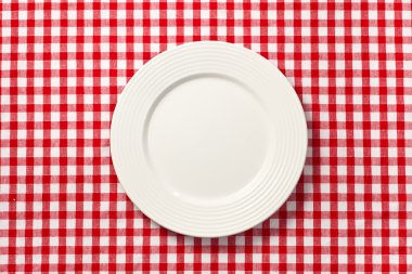 White plate on checkered tablecloth clipart