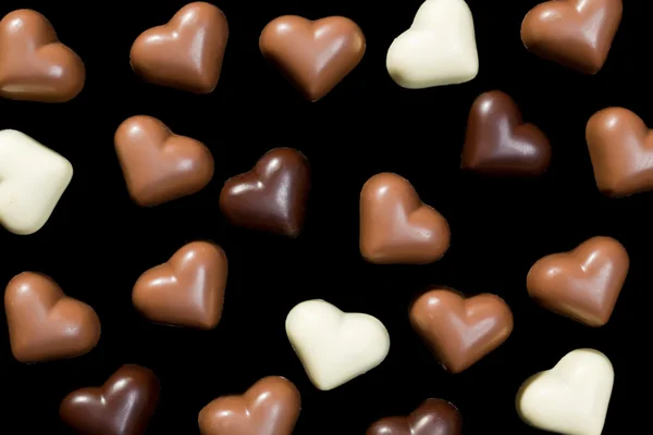 Chocolate hearts on black — Stock Photo, Image