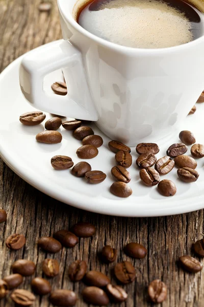 En kopp espresso med kaffebönor — Stockfoto