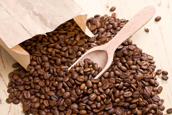 Kahve çekirdekleri üzerine ahşap Kepçe — Stok fotoğraf