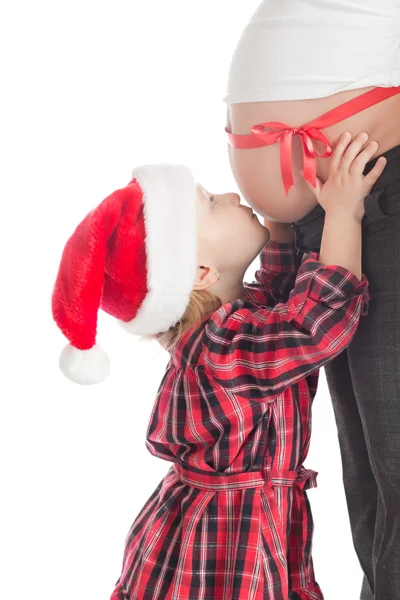 Little girl kissing christmas gift - pregnant mother — Stock Photo, Image
