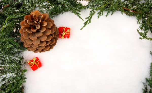 Auf Schnee liegende Tannenzapfen und Geschenkboxen — Stockfoto