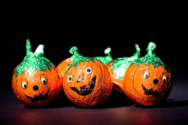 Comedy pumpkin chocolates close up on black — Stock Photo, Image