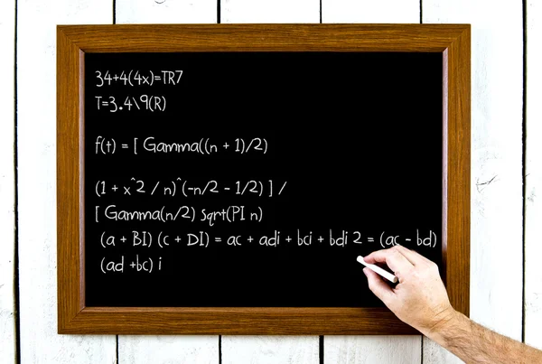 A hand writing formula on a chalkboard — Stock Photo, Image