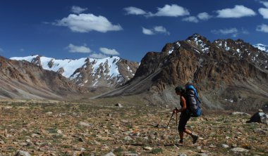 Hiker in high mountains clipart