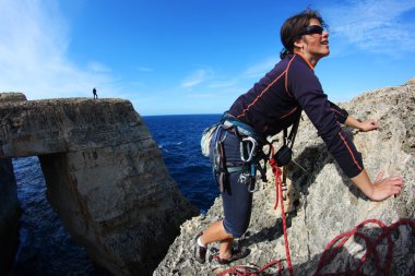 Rock climbing by the sea clipart