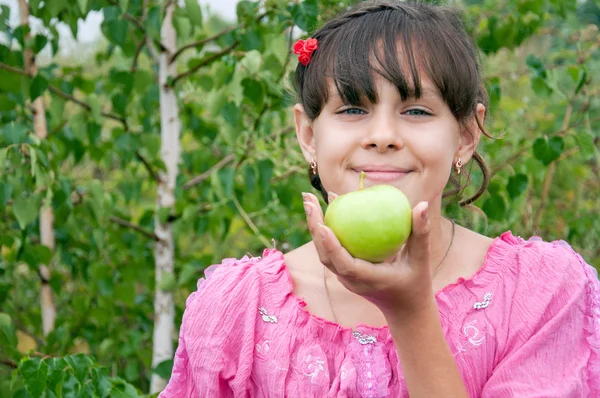 Dziewczyna z zielonym jabłkiem na tle brzoza — Zdjęcie stockowe