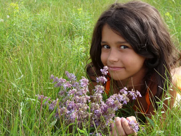 Uma menina bonita com um buquê de flores silvestres — Fotografia de Stock