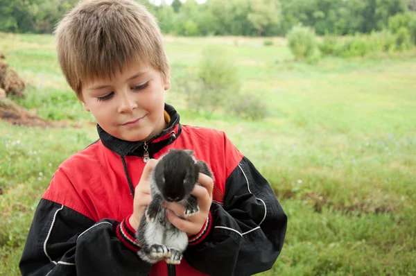 A boy with a rabbit outdoors — Stock Photo, Image