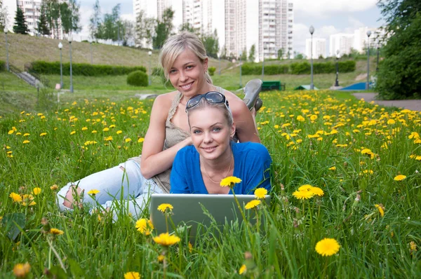 Två kvinnliga studenter med en laptop i parken — Stockfoto