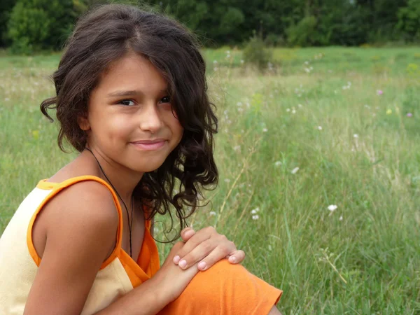 Retrato de uma menina de cabelos escuros em um prado — Fotografia de Stock