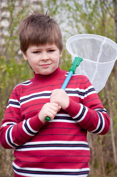 Мальчик с сеткой для бабочек для ловли бабочек — стоковое фото