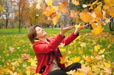 Beautiful young woman in autumn park with the leaves clipart